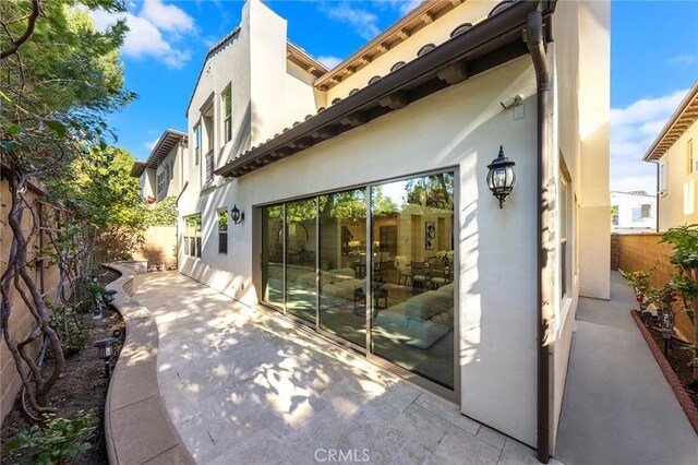 53 Interlude, Irvine, CA 92620 - rear view of house with stucco siding, a fenced backyard, and a patio