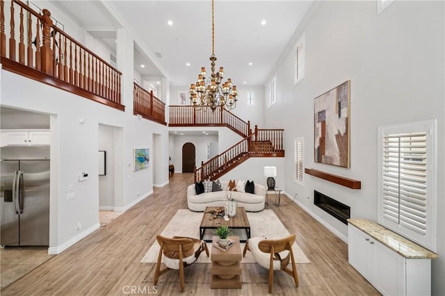 53 Interlude, Irvine, CA 92620 - living room with a towering ceiling, a glass covered fireplace, arched walkways, recessed lighting, and light wood-style flooring