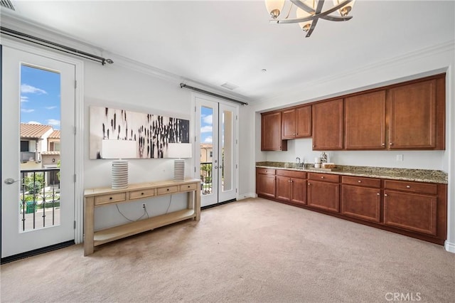 53 Interlude, Irvine, CA 92620 - kitchen featuring light colored carpet, brown cabinets, ornamental molding, and plenty of natural light