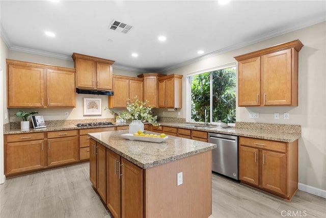 24912 Hearth Ct, Valencia, CA 91354 - kitchen with stainless steel appliances, ornamental molding, a kitchen island, light stone counters, and light wood finished floors
