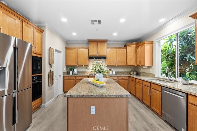 24912 Hearth Ct, Valencia, CA 91354 - kitchen featuring black appliances, crown molding, a center island, light wood finished floors, and light stone countertops