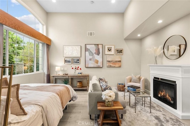 24912 Hearth Ct, Valencia, CA 91354 - bedroom featuring wood finished floors, a towering ceiling, recessed lighting, and a glass covered fireplace
