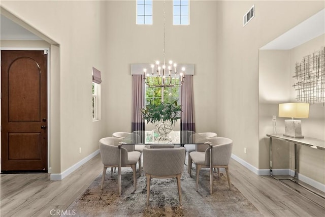 24912 Hearth Ct, Valencia, CA 91354 - dining room featuring a chandelier, a towering ceiling, and wood finished floors