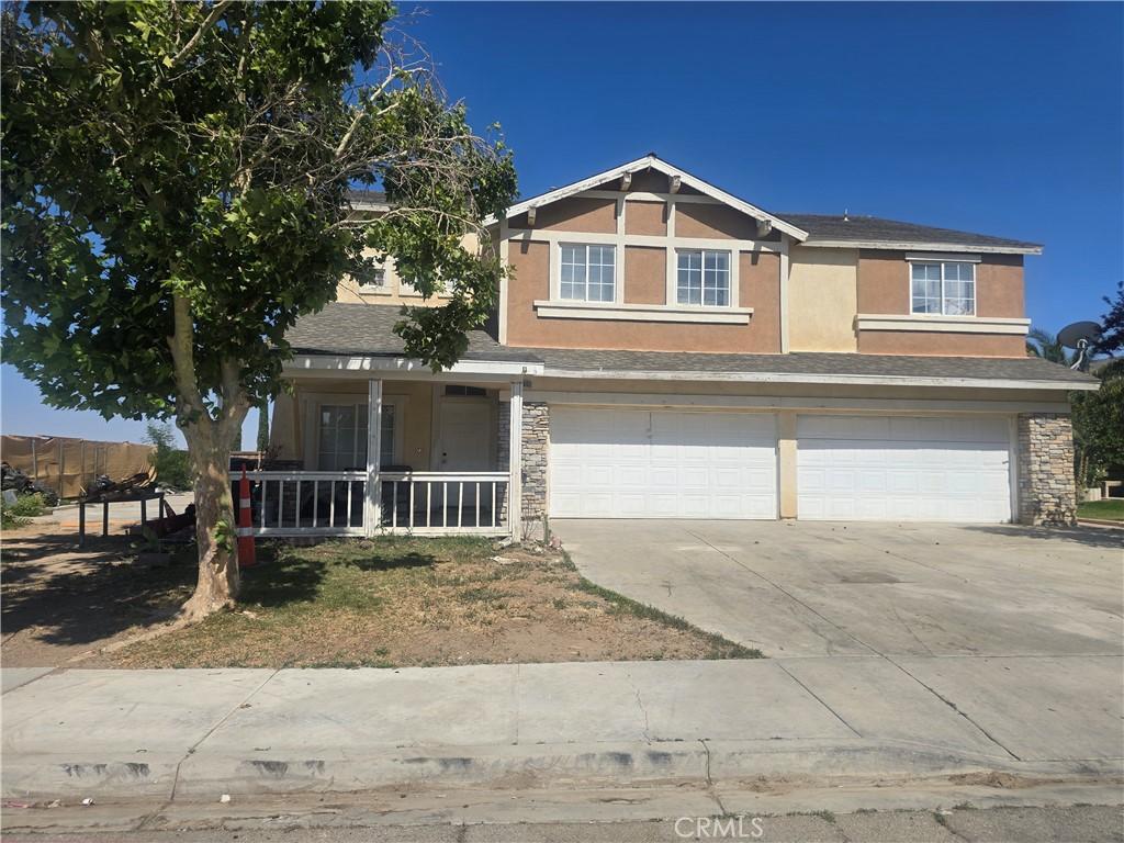 14693 Karen Dr, Victorville, CA 92394 - view of front of home featuring a garage, concrete driveway, stucco siding, covered porch, and stone siding