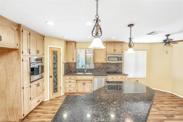 9425 Oak Hills Ave, Bakersfield, CA 93312 - kitchen featuring appliances with stainless steel finishes, light wood-type flooring, decorative backsplash, ceiling fan, and hanging light fixtures
