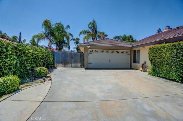 9425 Oak Hills Ave, Bakersfield, CA 93312 - view of side of property with stucco siding, an attached garage, driveway, a gate, and a tile roof