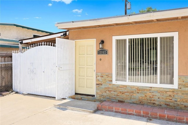 13162 Oaks Ave, Chino, CA 91710 - entrance to property with a gate, stucco siding, and stone siding