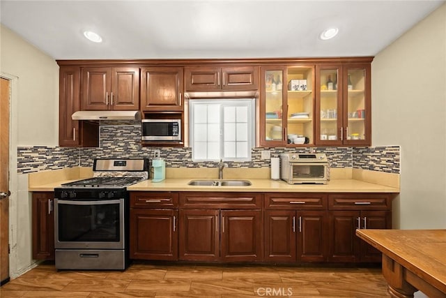 13162 Oaks Ave, Chino, CA 91710 - kitchen with appliances with stainless steel finishes, light countertops, glass insert cabinets, decorative backsplash, and light wood finished floors