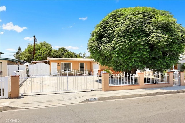 13162 Oaks Ave, Chino, CA 91710 - view of front of property with driveway, a fenced front yard, a gate, and stucco siding