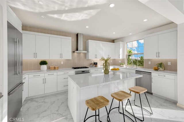 100 Soaring Eagle, Irvine, CA 92618 - kitchen with wall chimney exhaust hood, stainless steel appliances, a kitchen breakfast bar, light marble finish floors, and a kitchen island