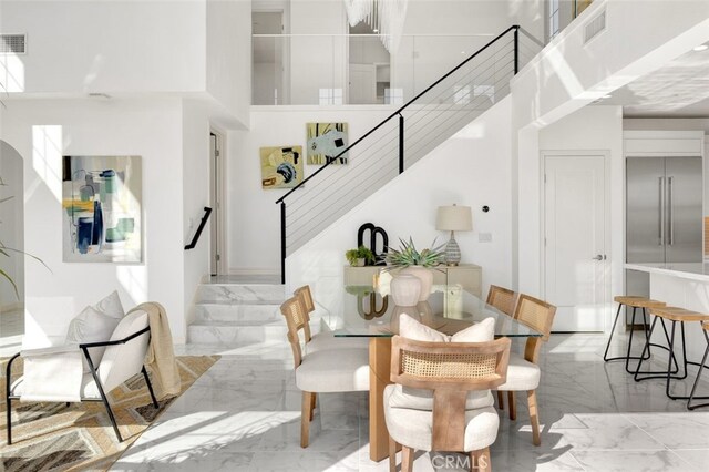 100 Soaring Eagle, Irvine, CA 92618 - dining area with light marble finish flooring, stairs, and a towering ceiling