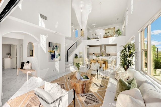 100 Soaring Eagle, Irvine, CA 92618 - living room featuring a towering ceiling, stairs, marble tiled floors, and arched walkways