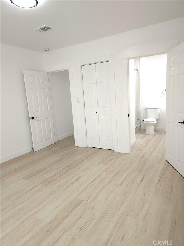 215 N Olive St, Anaheim, CA 92805 - unfurnished bedroom with light wood-style flooring, a closet, and ensuite bath