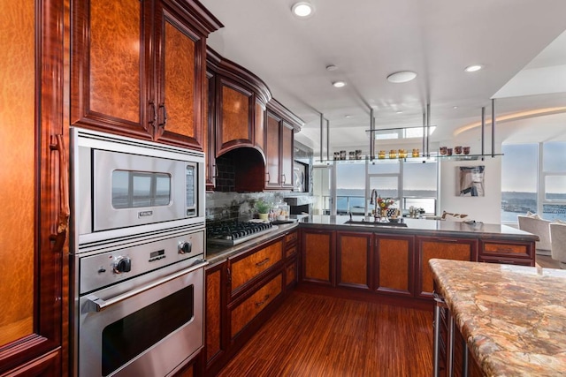 1325 Pacific Hwy Unit 3403, San Diego, CA 92101 - kitchen featuring stainless steel appliances, decorative backsplash, dark wood-style floors, recessed lighting, and a peninsula