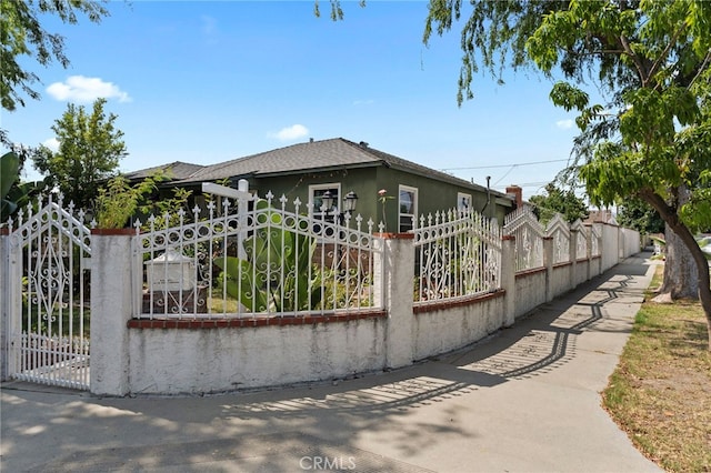 14057 Ohio St, Baldwin Park, CA 91706 - view of front of house with a fenced front yard, a gate, a shingled roof, and stucco siding