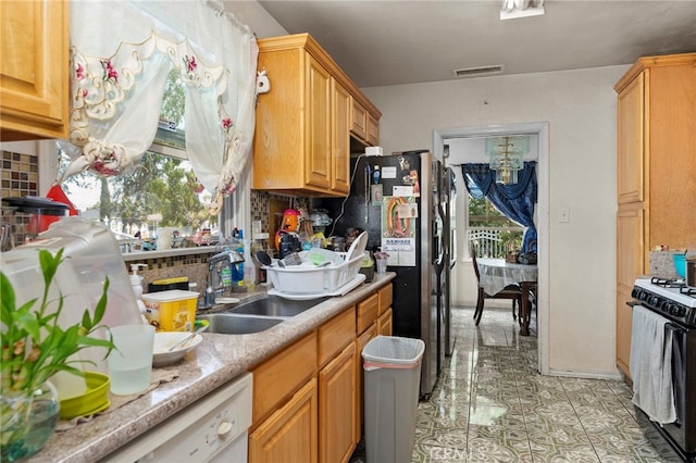 14057 Ohio St, Baldwin Park, CA 91706 - kitchen with gas range oven, backsplash, light countertops, light tile patterned floors, and black fridge with ice dispenser