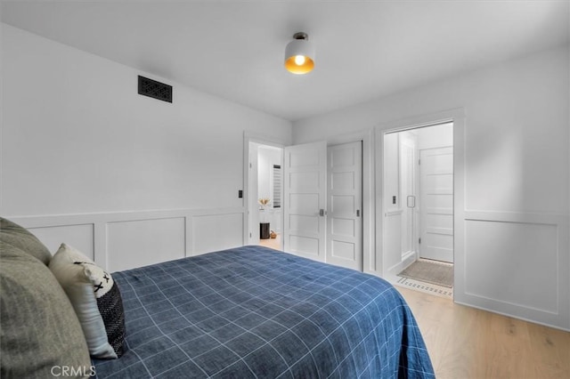 1012 10th St, Manhattan Beach, CA 90266 - bedroom with wood finished floors, ensuite bathroom, and a wainscoted wall