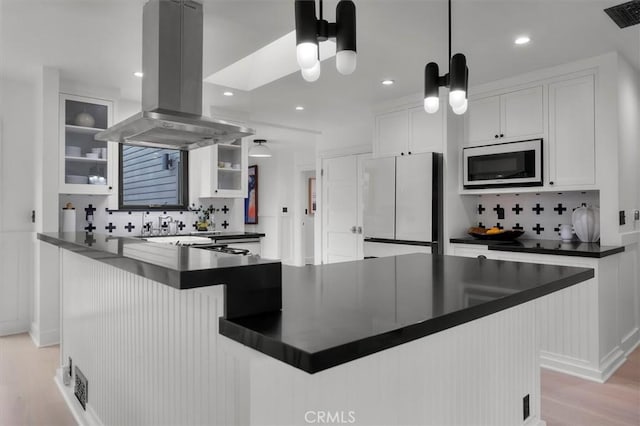 1012 10th St, Manhattan Beach, CA 90266 - kitchen featuring white microwave, island range hood, freestanding refrigerator, dark countertops, and backsplash