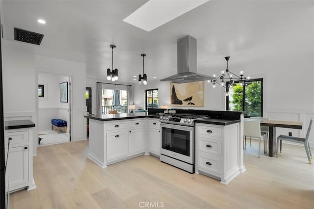 1012 10th St, Manhattan Beach, CA 90266 - kitchen with island range hood, a chandelier, stainless steel gas stove, dark countertops, and light wood finished floors