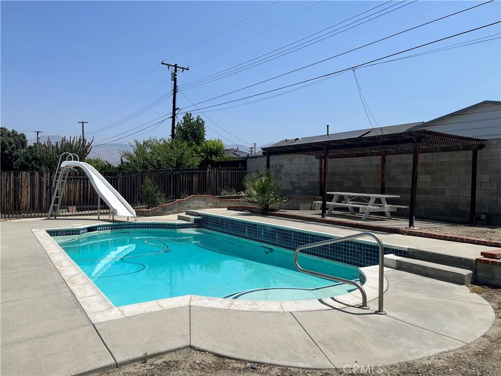 1424 Hunter Dr, Redlands, CA 92374 - view of pool featuring a water slide, a pergola, a fenced backyard, and a patio area