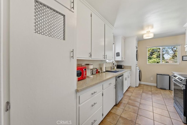 213 E 45th St, Long Beach, CA 90807 - kitchen featuring stacked washer / drying machine, appliances with stainless steel finishes, light countertops, and white cabinetry