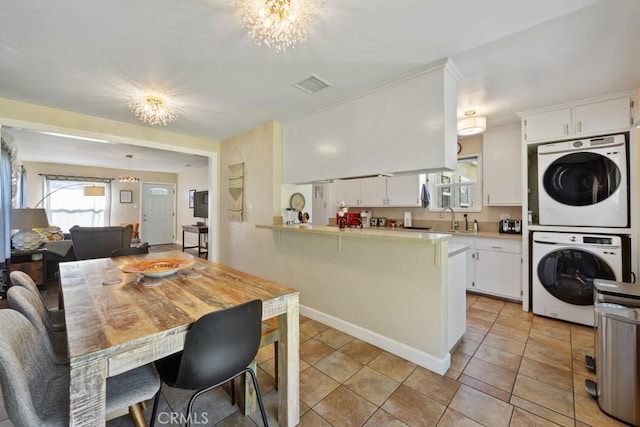 213 E 45th St, Long Beach, CA 90807 - dining room with stacked washer / dryer, a chandelier, and plenty of natural light
