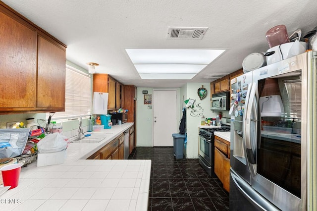 14134 Orizaba Ave, Paramount, CA 90723 - kitchen featuring stainless steel appliances, brown cabinetry, and tile countertops