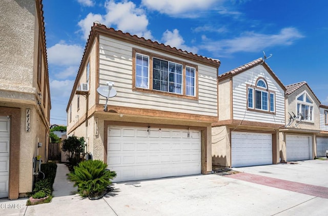 14134 Orizaba Ave, Paramount, CA 90723 - townhome / multi-family property featuring an attached garage, driveway, a tiled roof, and stucco siding