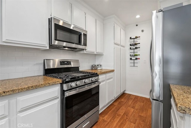 260 Cagney Ln Unit 206, Newport Beach, CA 92663 - kitchen featuring stainless steel appliances, wood finished floors, white cabinetry, decorative backsplash, and recessed lighting