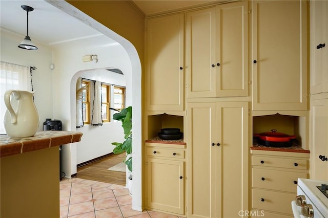 413 W Santa Clara Ave, Santa Ana, CA 92706 - kitchen featuring cream cabinetry, arched walkways, and healthy amount of natural light