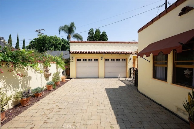 413 W Santa Clara Ave, Santa Ana, CA 92706 - view of patio featuring decorative driveway and a garage
