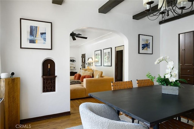 413 W Santa Clara Ave, Santa Ana, CA 92706 - dining area with arched walkways, wood finished floors, a chandelier, and a ceiling fan