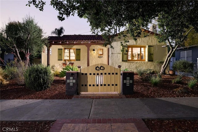 413 W Santa Clara Ave, Santa Ana, CA 92706 - view of front of home featuring stucco siding, a tile roof, and a gate