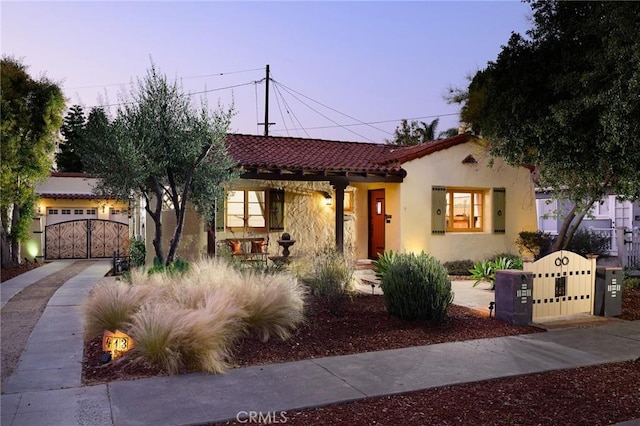 413 W Santa Clara Ave, Santa Ana, CA 92706 - mediterranean / spanish-style house with stucco siding, a garage, a tiled roof, driveway, and a gate