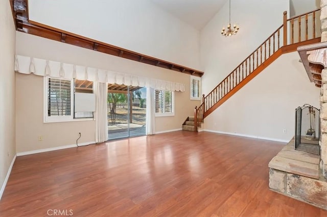 29801 Maxine Ln, Menifee, CA 92584 - unfurnished living room featuring stairway, wood finished floors, a towering ceiling, and a chandelier
