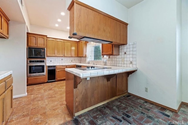 29801 Maxine Ln, Menifee, CA 92584 - kitchen featuring black appliances, a peninsula, tasteful backsplash, a kitchen breakfast bar, and tile countertops