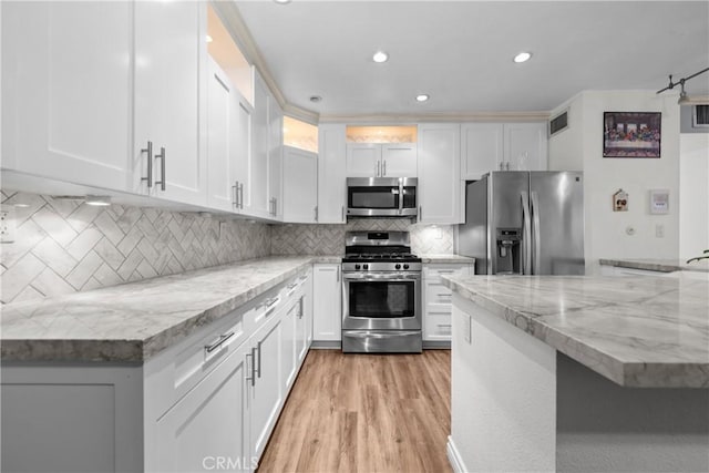 3611 S Bear St Unit D, Santa Ana, CA 92704 - kitchen featuring appliances with stainless steel finishes, white cabinetry, light wood finished floors, tasteful backsplash, and recessed lighting