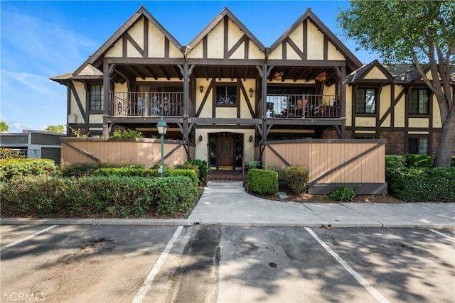 3611 S Bear St Unit D, Santa Ana, CA 92704 - english style home with stucco siding, a balcony, and uncovered parking