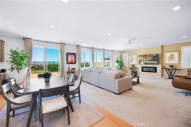 11534 Alana Ln, Beaumont, CA 92223 - dining area featuring a glass covered fireplace, recessed lighting, light carpet, and a ceiling fan
