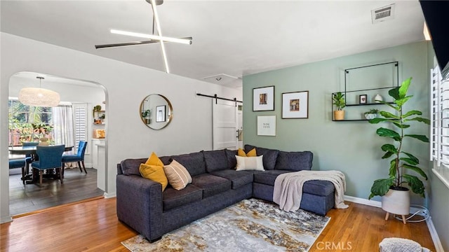 3209 Bennett Dr, Los Angeles, CA 90068 - living area with a barn door, wood finished floors, arched walkways, and ceiling fan