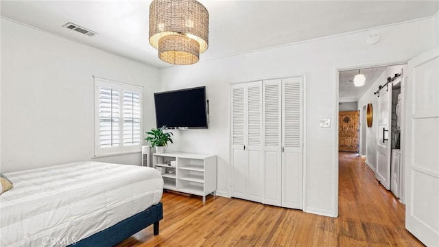 3209 Bennett Dr, Los Angeles, CA 90068 - bedroom with a barn door, hardwood / wood-style floors, a chandelier, and a closet