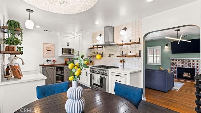 3209 Bennett Dr, Los Angeles, CA 90068 - kitchen with stainless steel appliances, island exhaust hood, backsplash, white cabinets, and wood finished floors