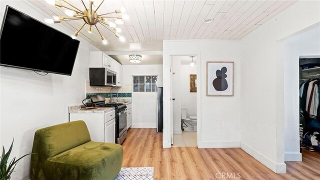 3209 Bennett Dr, Los Angeles, CA 90068 - kitchen with stainless steel appliances, light countertops, light wood-style floors, white cabinets, and wooden ceiling