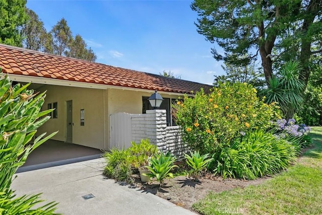 933 Avenida Majorca Unit P, Laguna Woods, CA 92637 - view of exterior entry featuring a tile roof and stucco siding