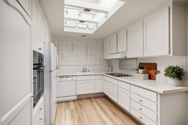 933 Avenida Majorca Unit P, Laguna Woods, CA 92637 - kitchen featuring black appliances, rail lighting, white cabinets, light wood-type flooring, and under cabinet range hood