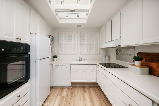 933 Avenida Majorca Unit P, Laguna Woods, CA 92637 - kitchen featuring black appliances, rail lighting, white cabinetry, under cabinet range hood, and light wood-style floors