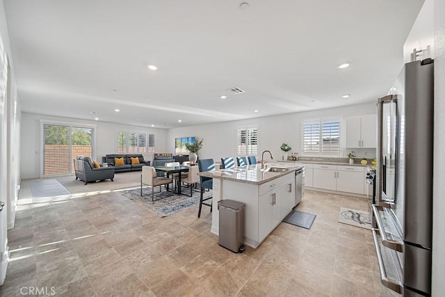 30701 Noble Ct, Homeland, CA 92548 - kitchen featuring stainless steel appliances, healthy amount of natural light, a center island with sink, white cabinetry, and recessed lighting