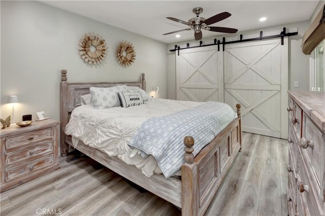 33081 Regatta Ct, San Juan Capistrano, CA 92675 - bedroom featuring a barn door, light wood-style floors, recessed lighting, and a ceiling fan
