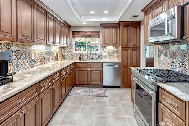 33081 Regatta Ct, San Juan Capistrano, CA 92675 - kitchen with stainless steel appliances, tasteful backsplash, brown cabinetry, light stone counters, and recessed lighting
