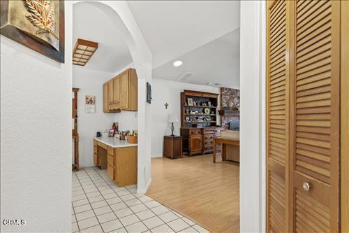 22820 Mariposa Rd, Tehachapi, CA 93561 - hallway with light tile patterned flooring, vaulted ceiling, arched walkways, and recessed lighting